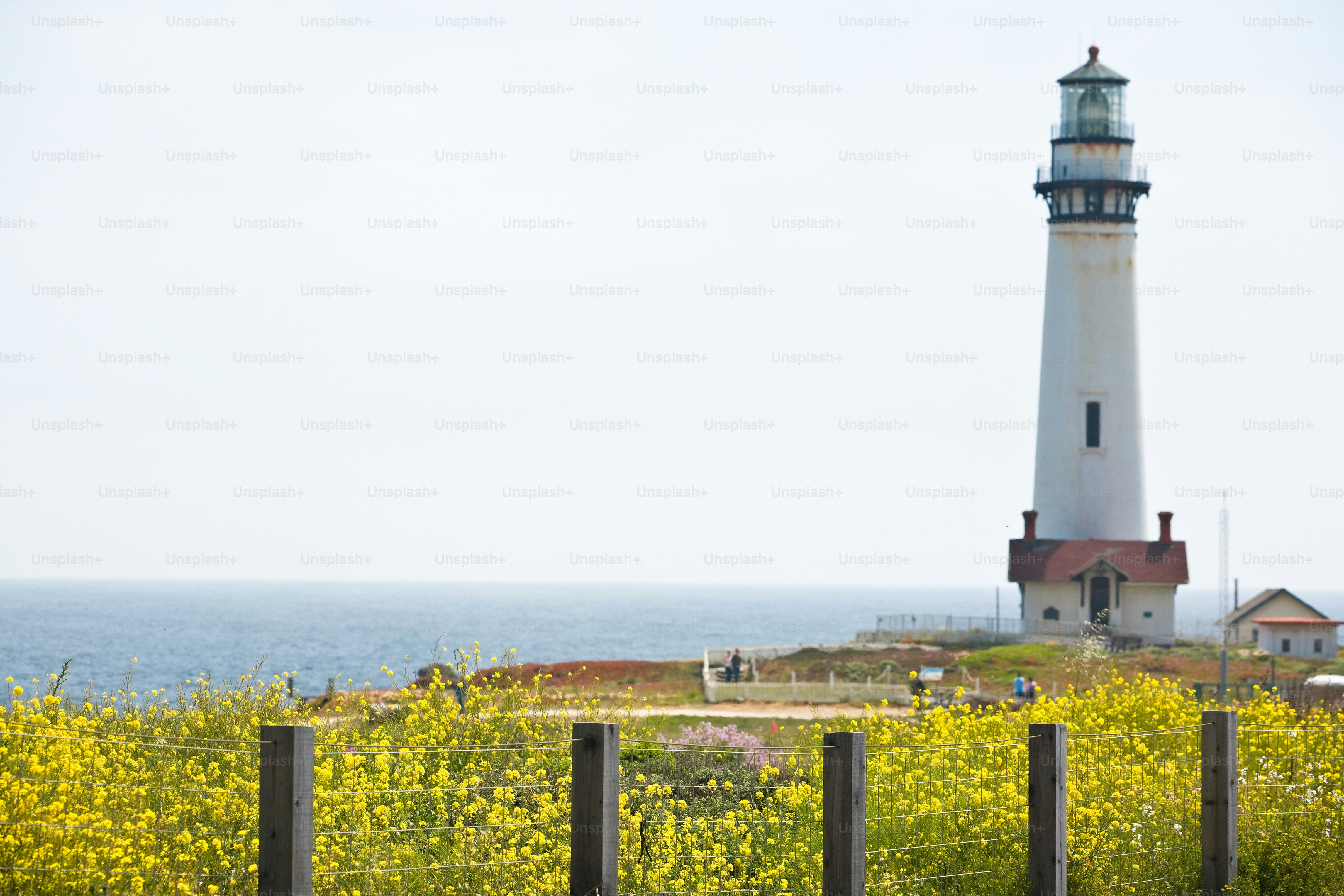 a light house sitting on top of a lush green field
