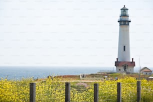 a light house sitting on top of a lush green field