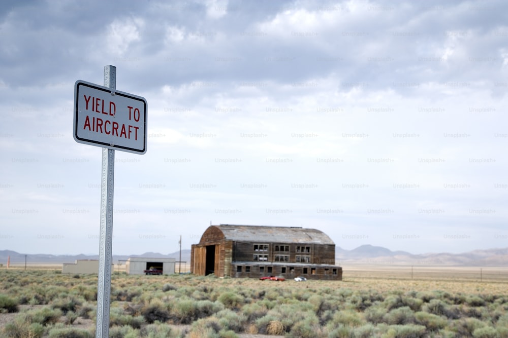 Ein Feld mit einem Gebäude und einem Schild mit der Aufschrift "Yield to Aircraft"