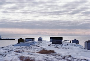 a group of small houses sitting on top of a snow covered hill