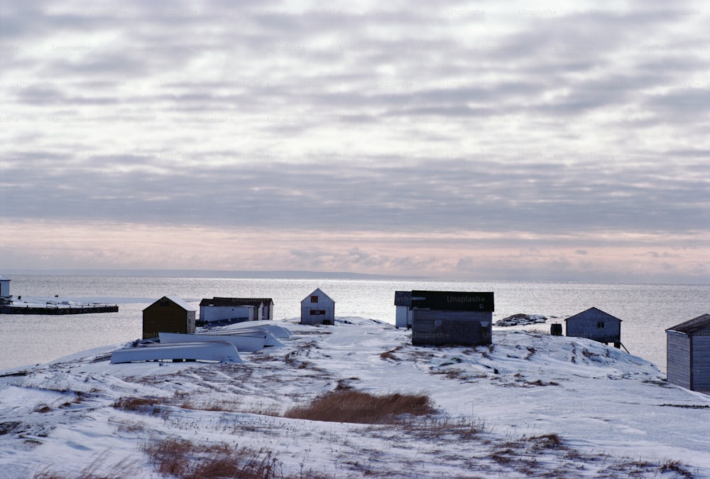 a group of small houses sitting on top of a snow covered hill