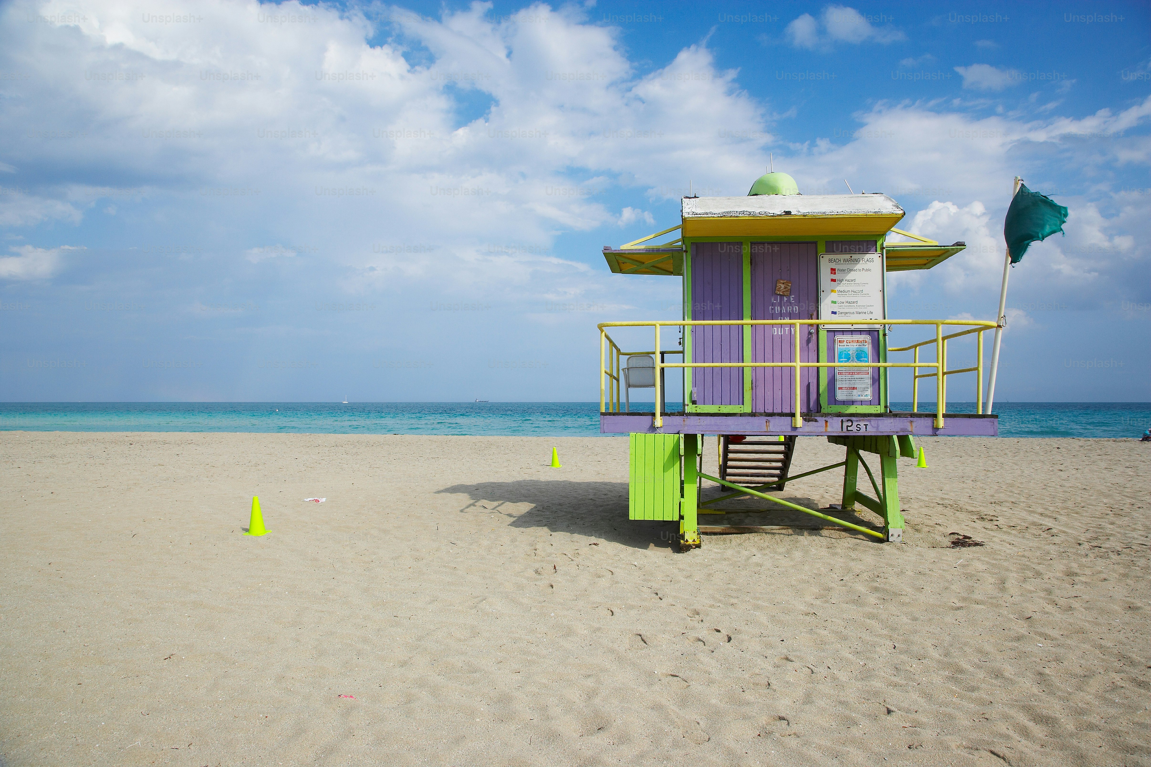 Ein Rettungsschwimmer steht an einem Strand mit blauem Himmel im Hintergrund