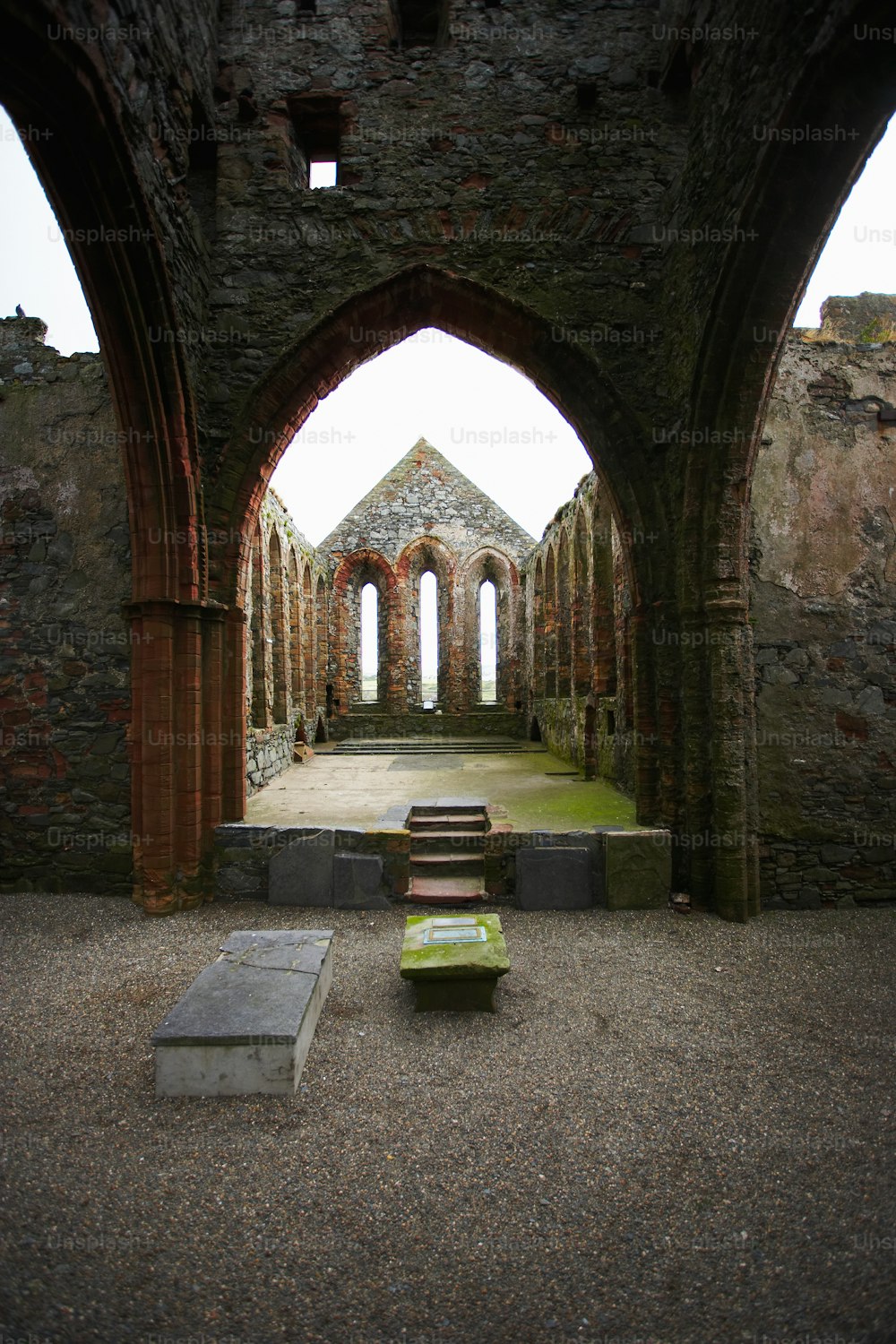 a stone building with two benches in the middle of it