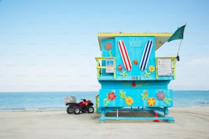 a lifeguard stand on the beach with a toy truck parked in front of it