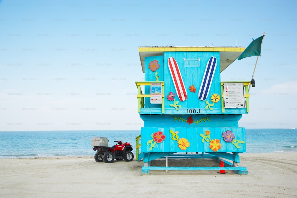 Un bagnino sulla spiaggia con un camion giocattolo parcheggiato di fronte ad esso