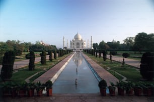 Un grand bâtiment blanc avec un long bassin d’eau devant lui