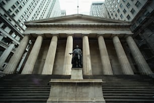 une statue d’un homme debout devant un bâtiment