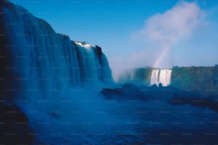 a large waterfall with a rainbow in the middle of it