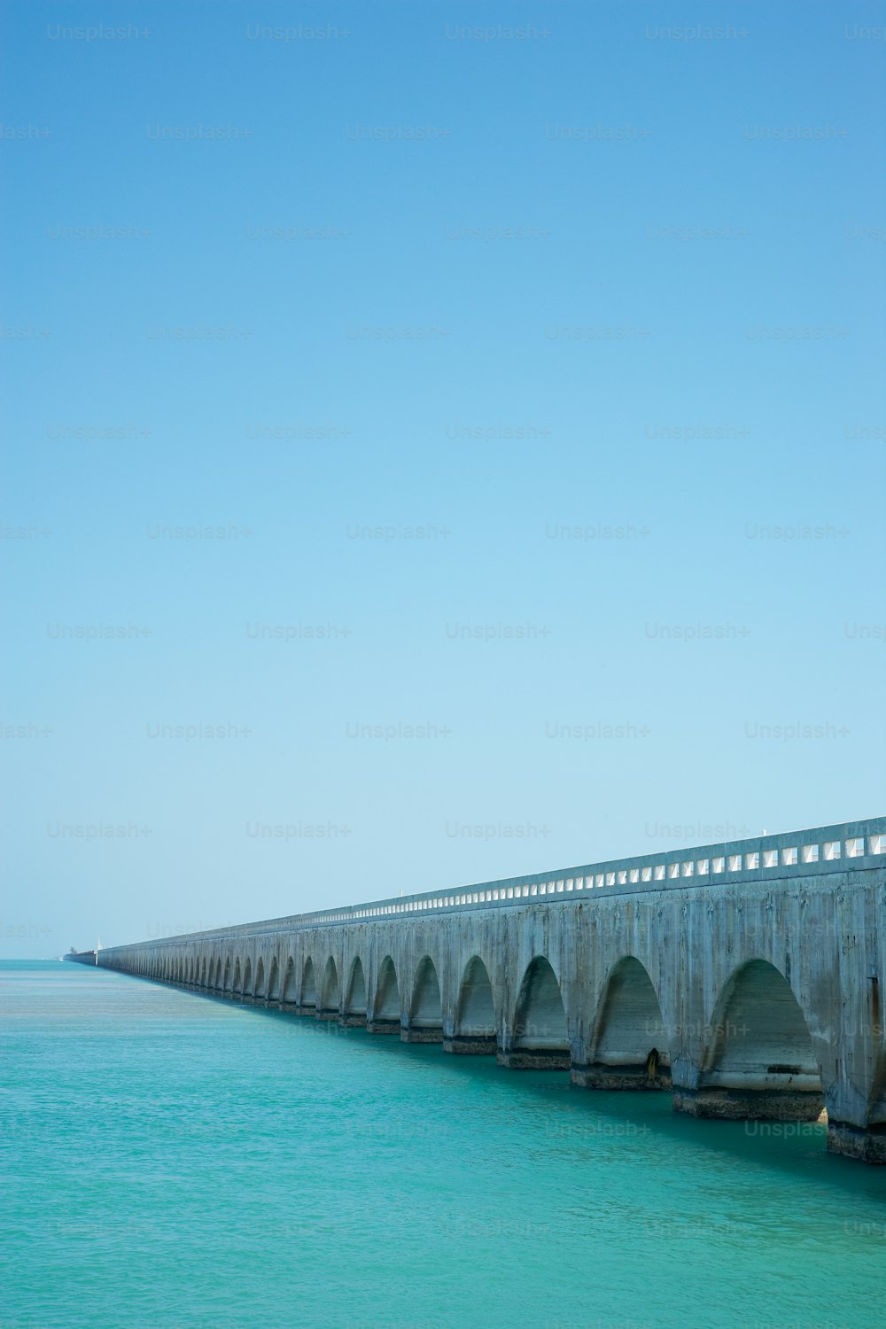 eine lange Betonbrücke über ein Gewässer