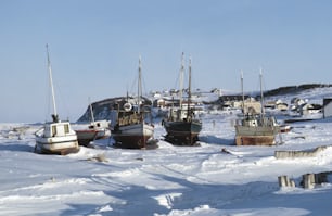 a group of boats that are sitting in the snow