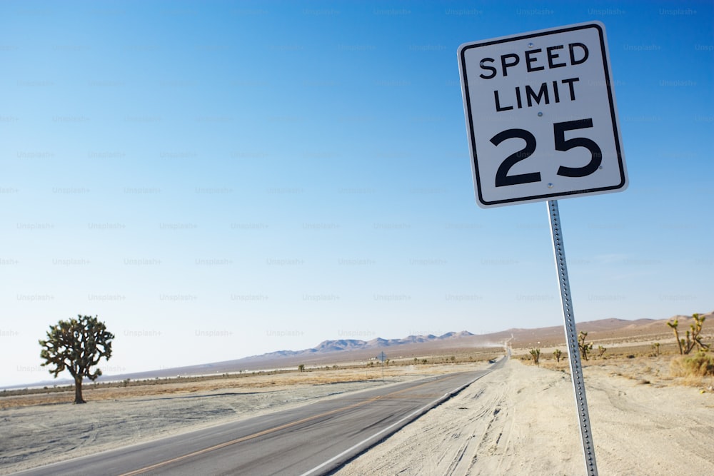 um sinal de limite de velocidade sentado na beira de uma estrada