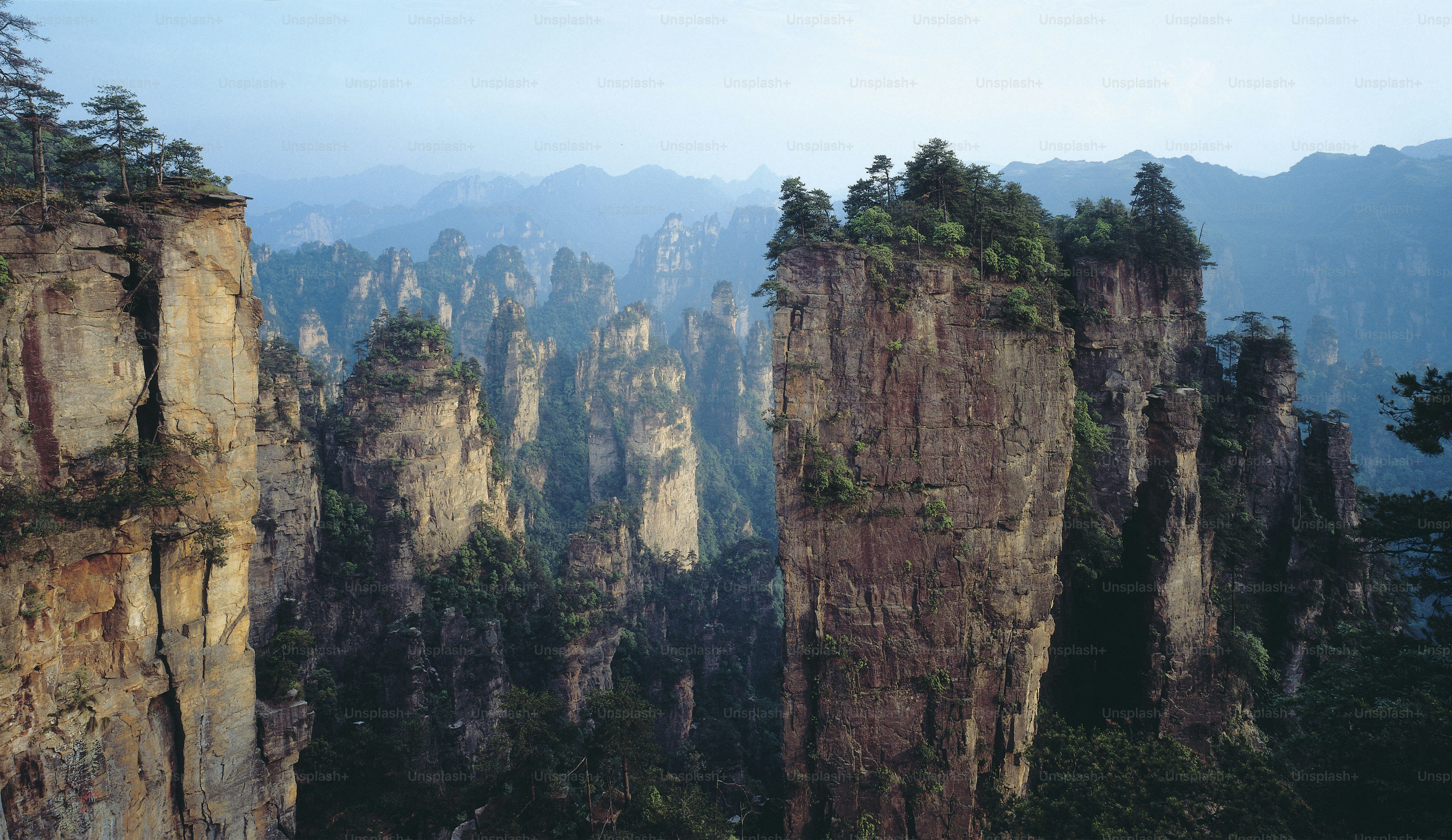 A group of tall rocks with trees on top of them photo – Mountain Image ...