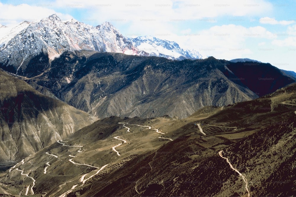 a view of a mountain range with a winding road in the foreground