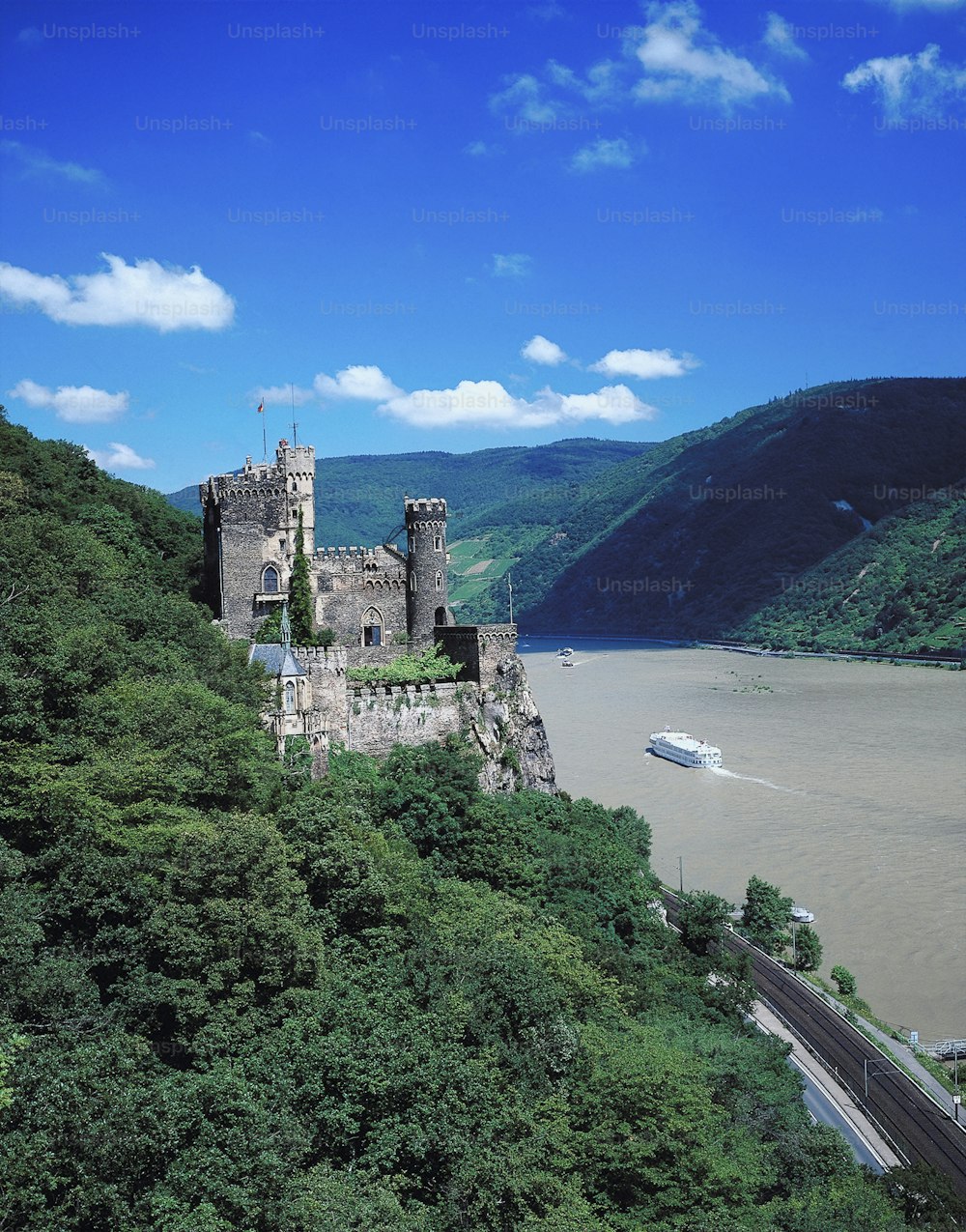 a castle sitting on top of a lush green hillside