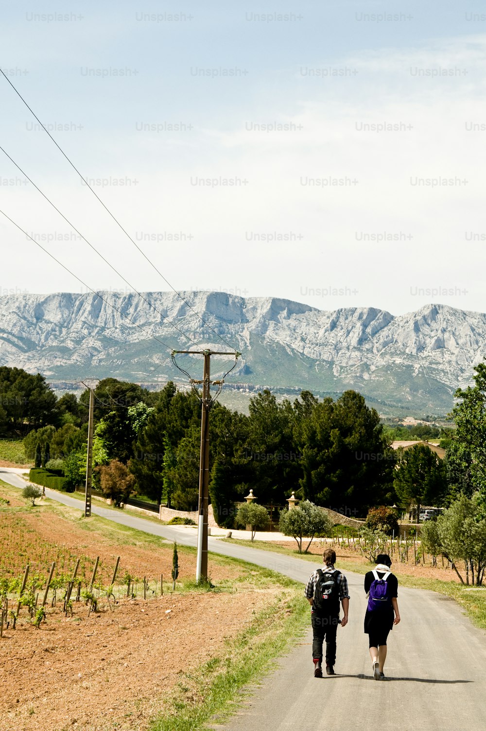 a couple of people walking down a dirt road