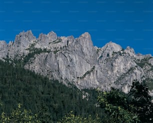 a very tall mountain with some trees in front of it