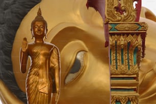a golden buddha statue next to a golden clock