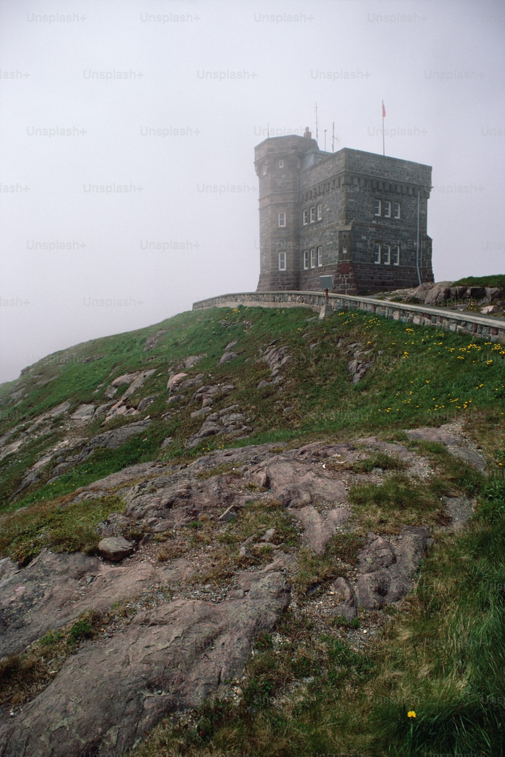 a stone building on top of a grassy hill