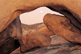 a rock formation with a full moon in the background