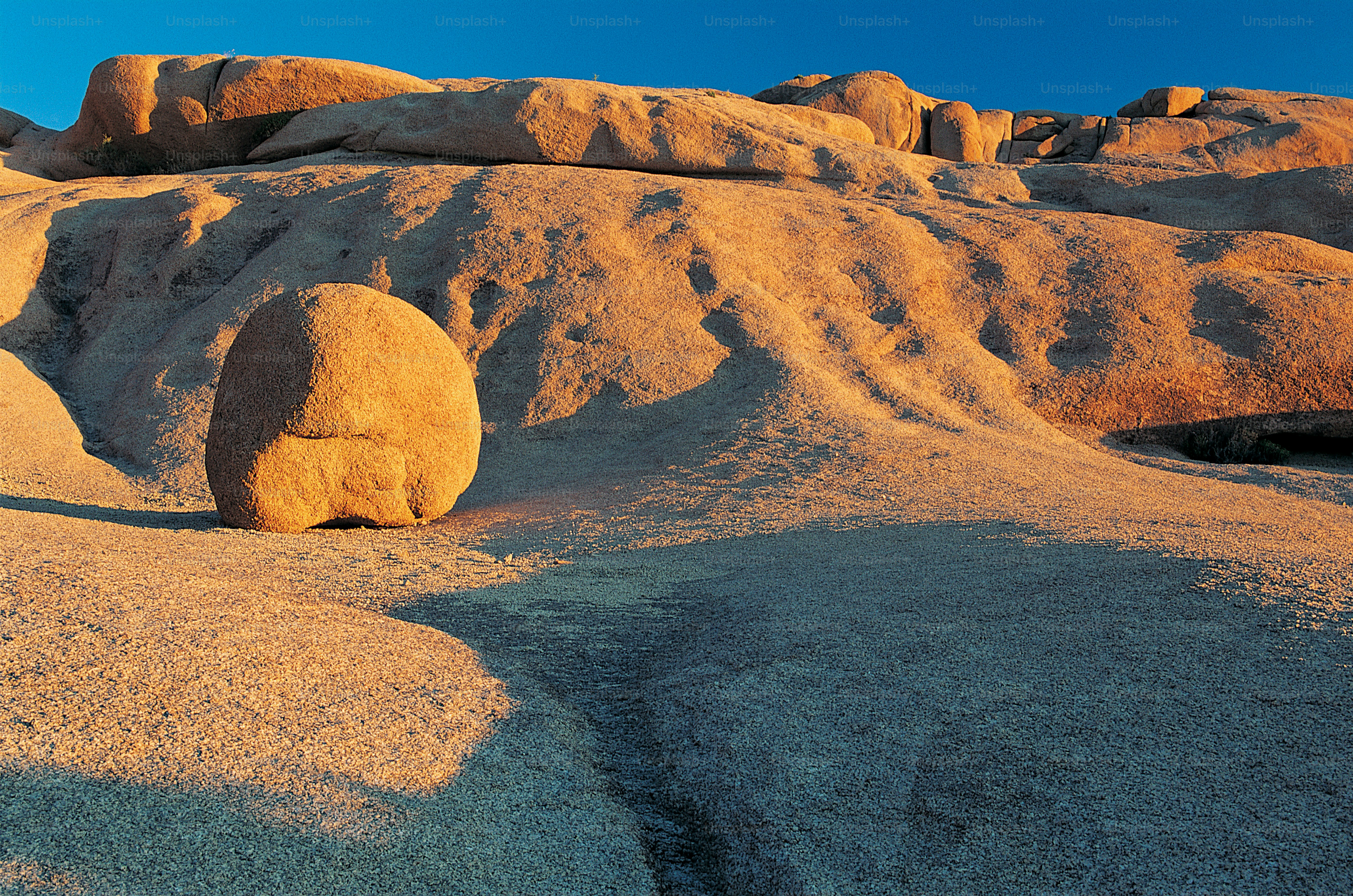 a large rock in the middle of a desert