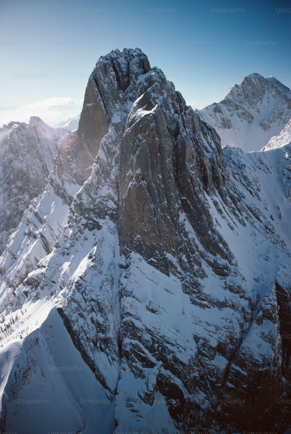 a very tall mountain covered in snow with a sky background