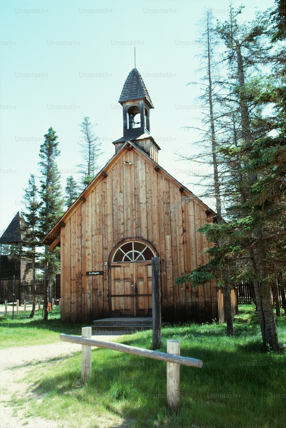 a wooden church with a steeple and a clock tower