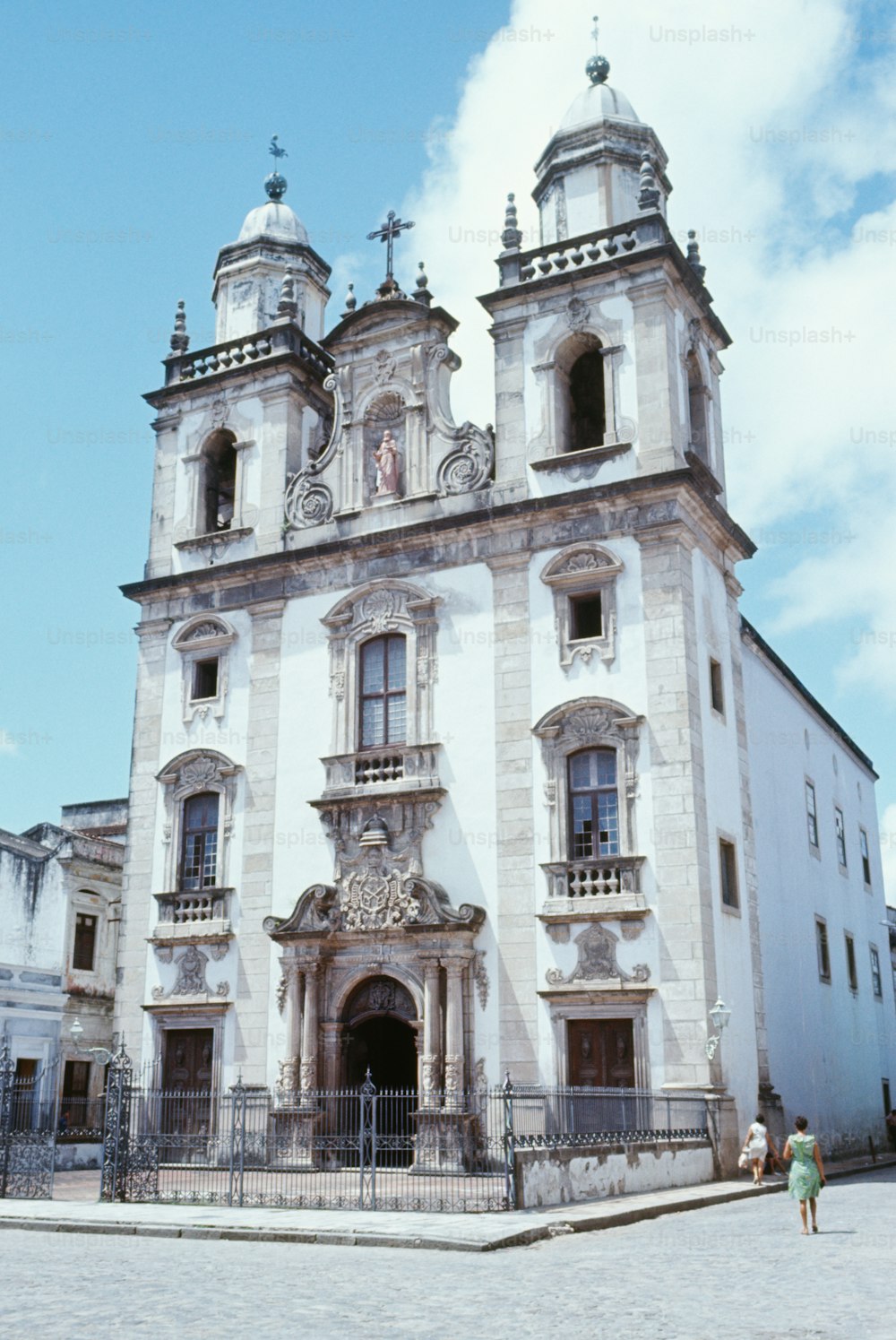 um grande edifício branco com um relógio ao seu lado