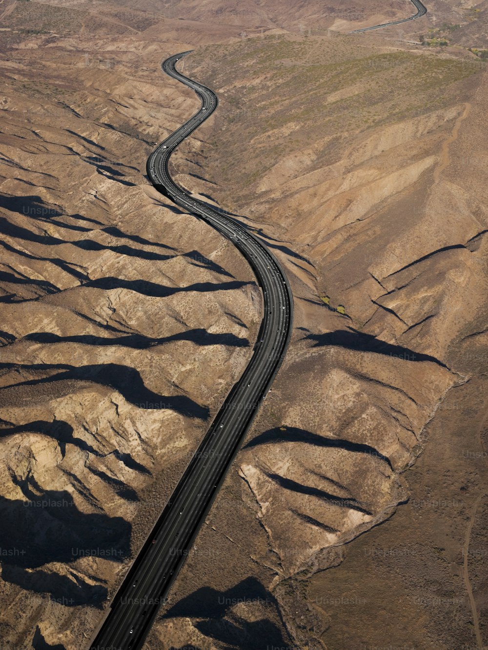 an aerial view of a winding road in the desert