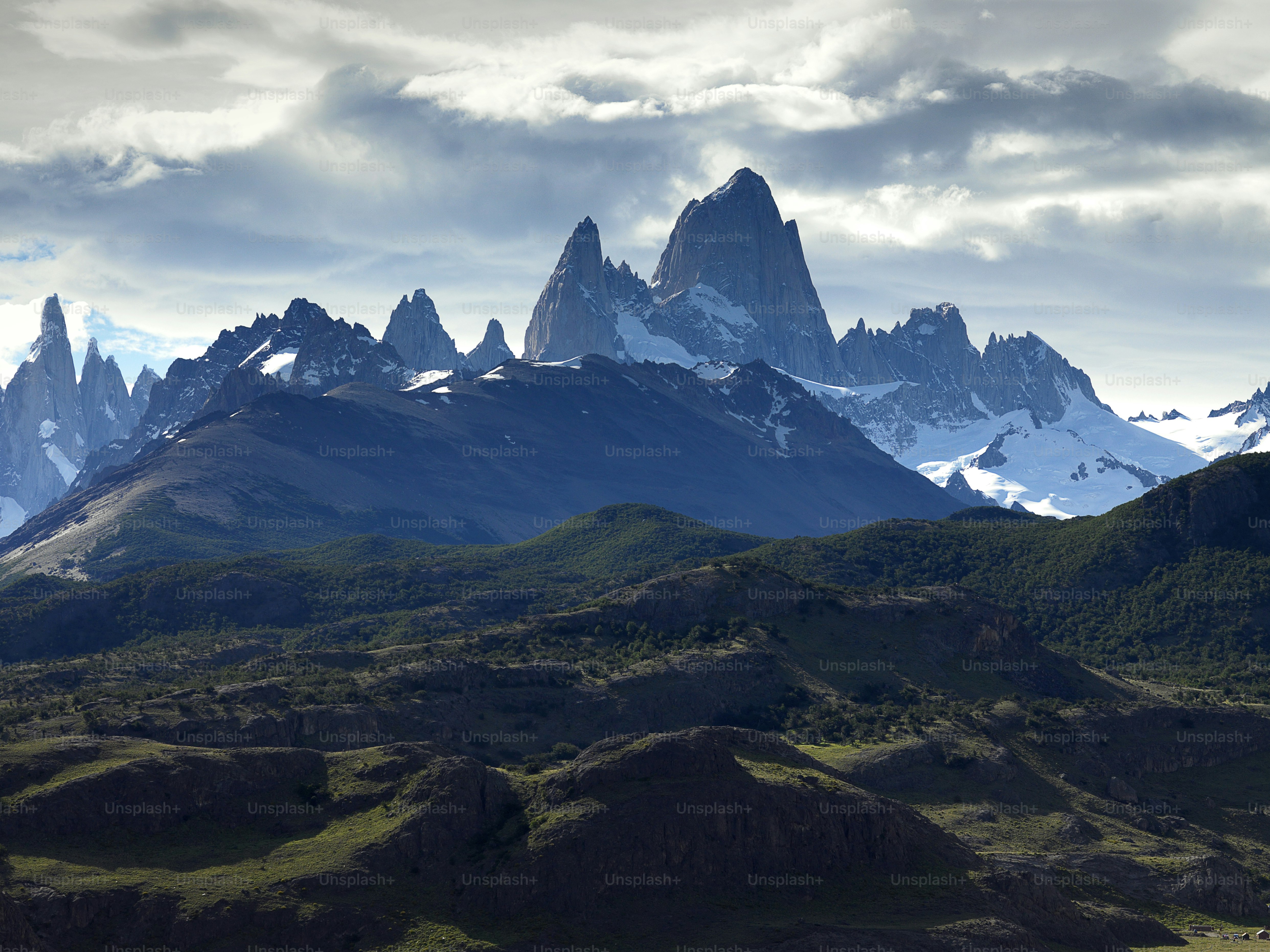a mountain range with snow capped mountains in the background