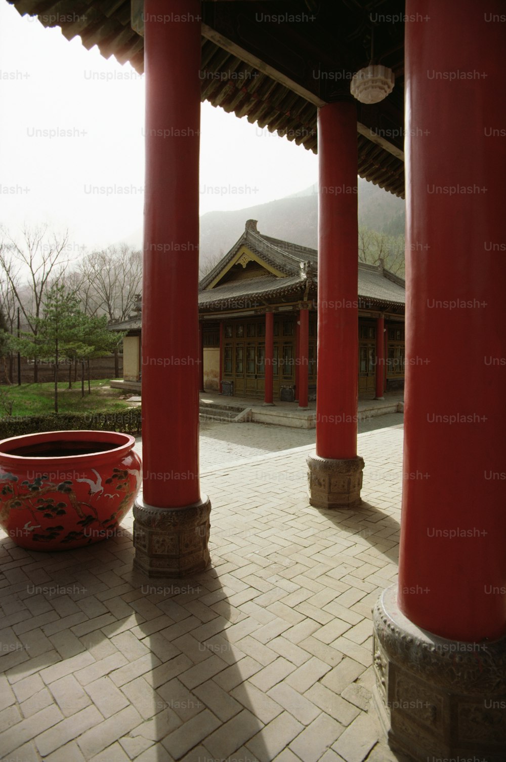 a large red bowl sitting on top of a stone floor