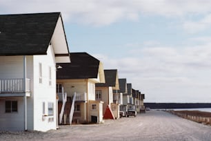 une rangée de maisons sur un chemin de terre à côté d’un plan d’eau