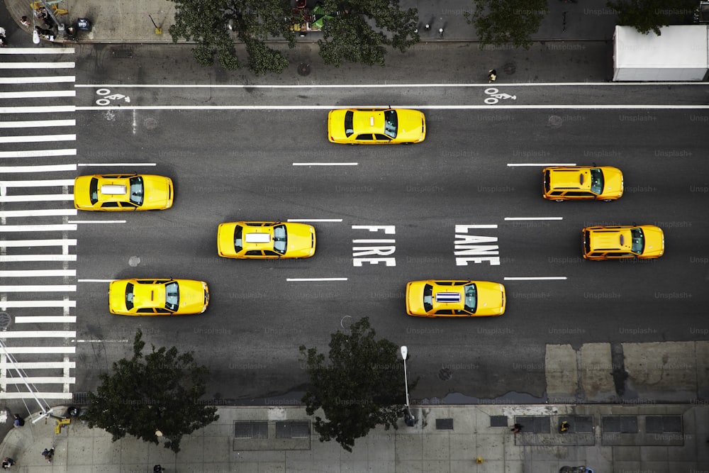 a group of yellow taxis driving down a street