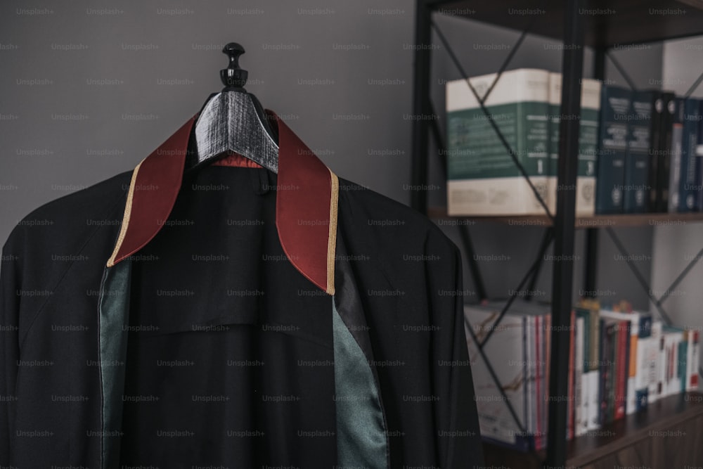 a coat hanging on a book shelf in a room