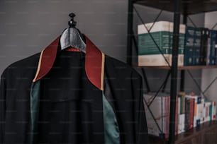 a coat hanging on a book shelf in a room