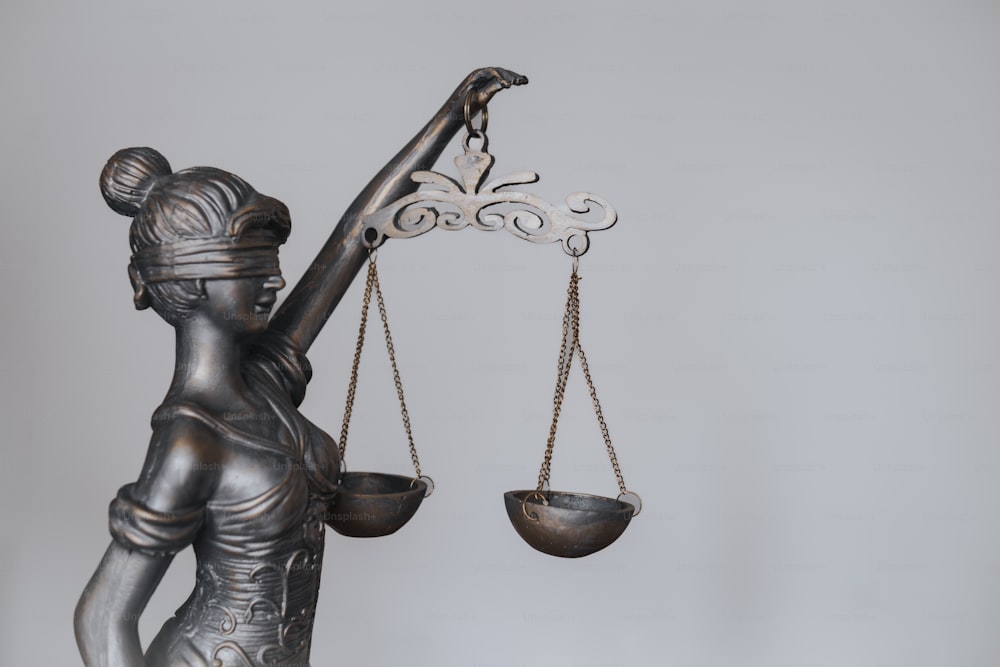 Una estatua de una dama de la justicia sosteniendo una balanza de justicia