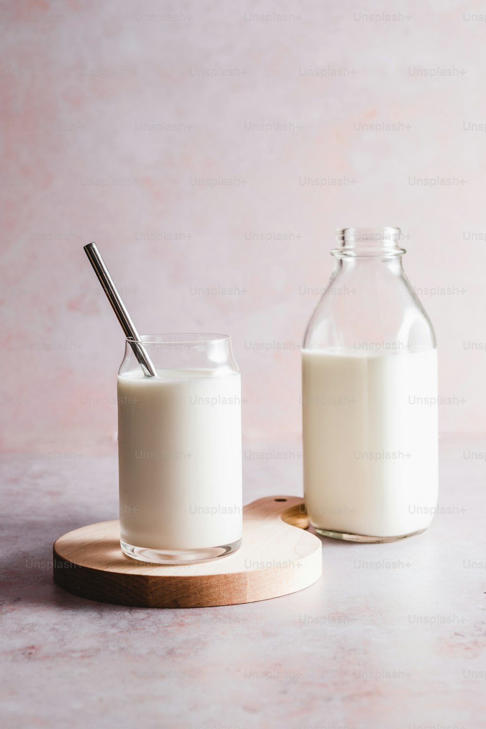 un vaso de leche junto a una botella de leche