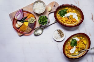 three bowls of food on a table with spoons