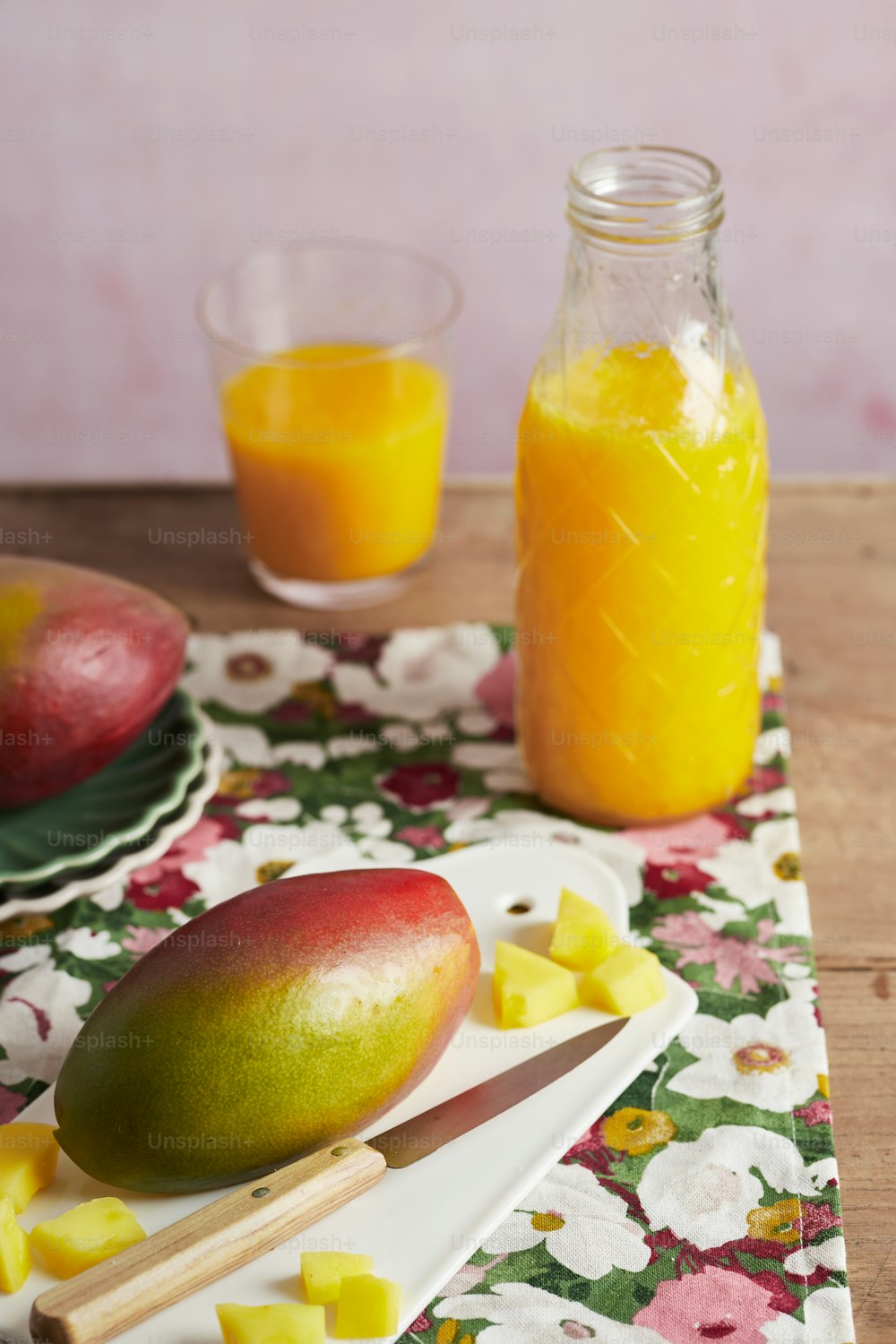 uma mesa coberta com um prato de frutas ao lado de um pote de suco de laranja
