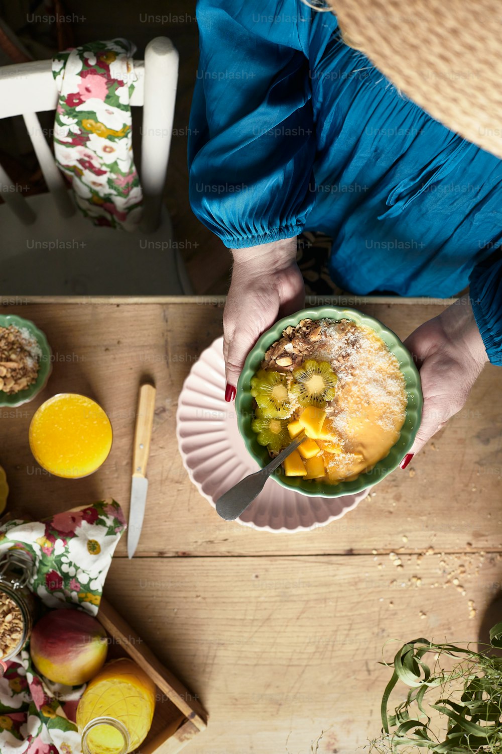 a person holding a bowl of food on top of a wooden table