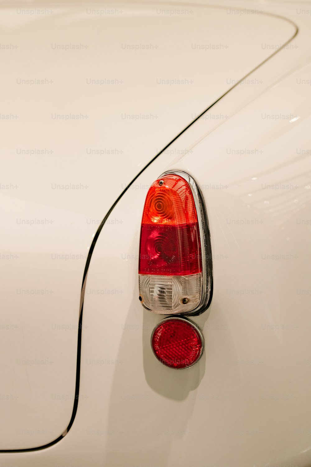 a close up of a white car with a red light