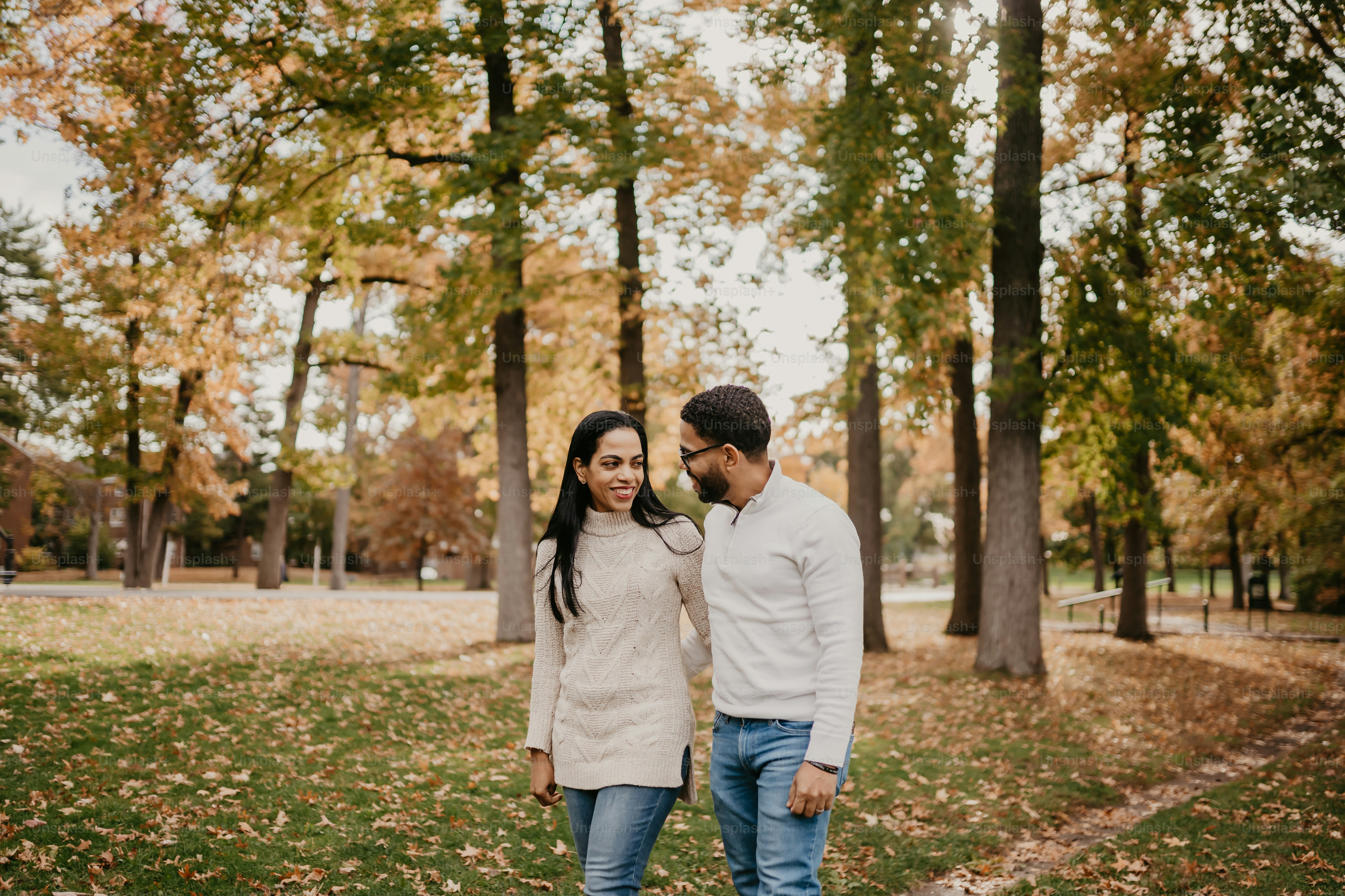 A man and a woman walking through a park photo – Couple Image on Unsplash