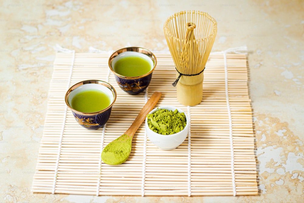 three cups of green tea on a bamboo mat