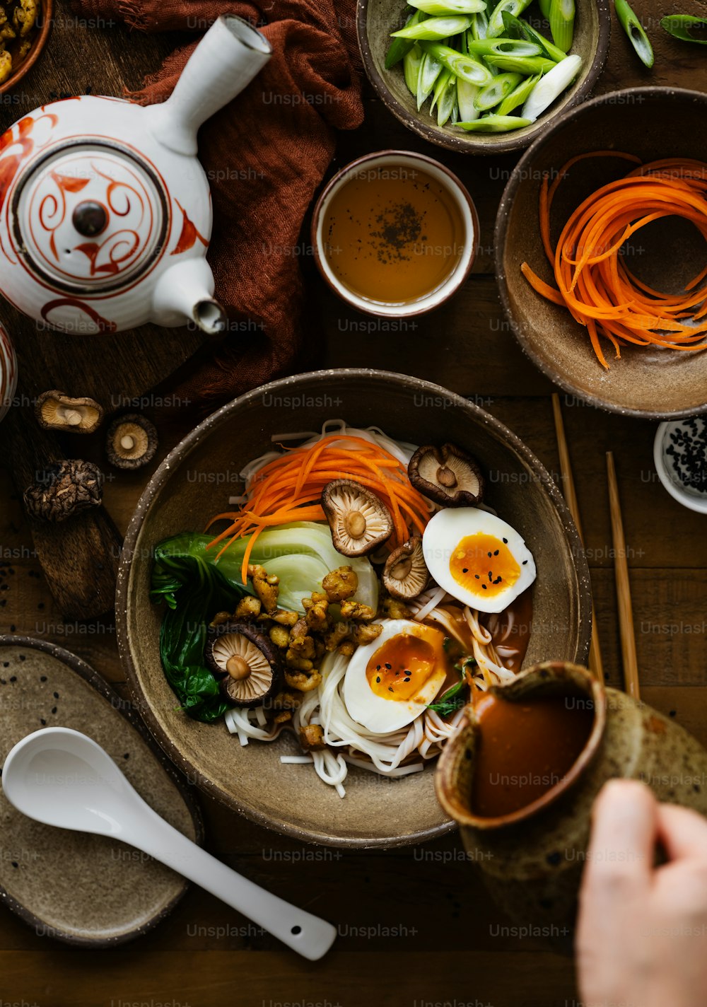 a bowl of noodles, carrots, and other vegetables