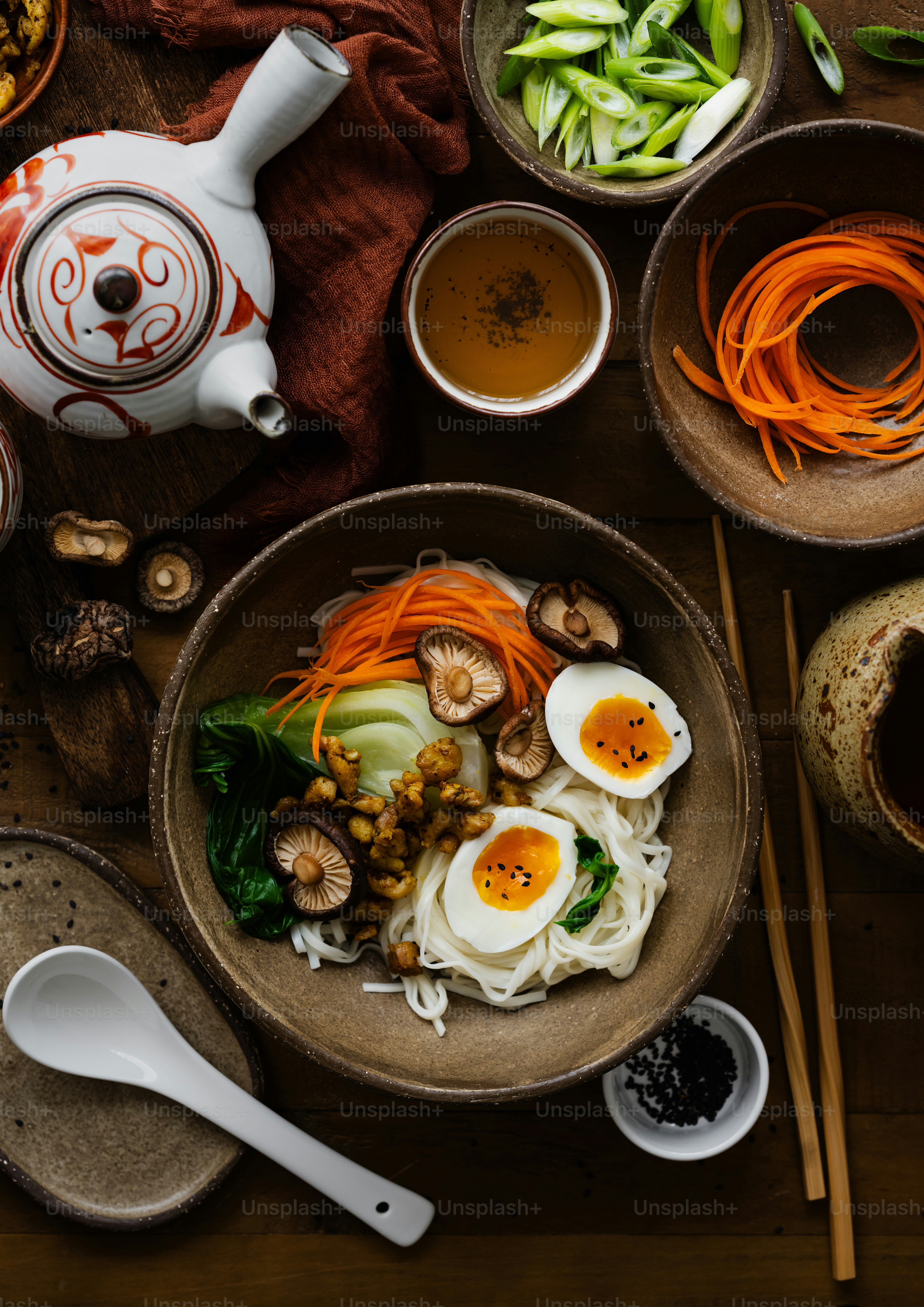 a wooden table topped with bowls filled with food