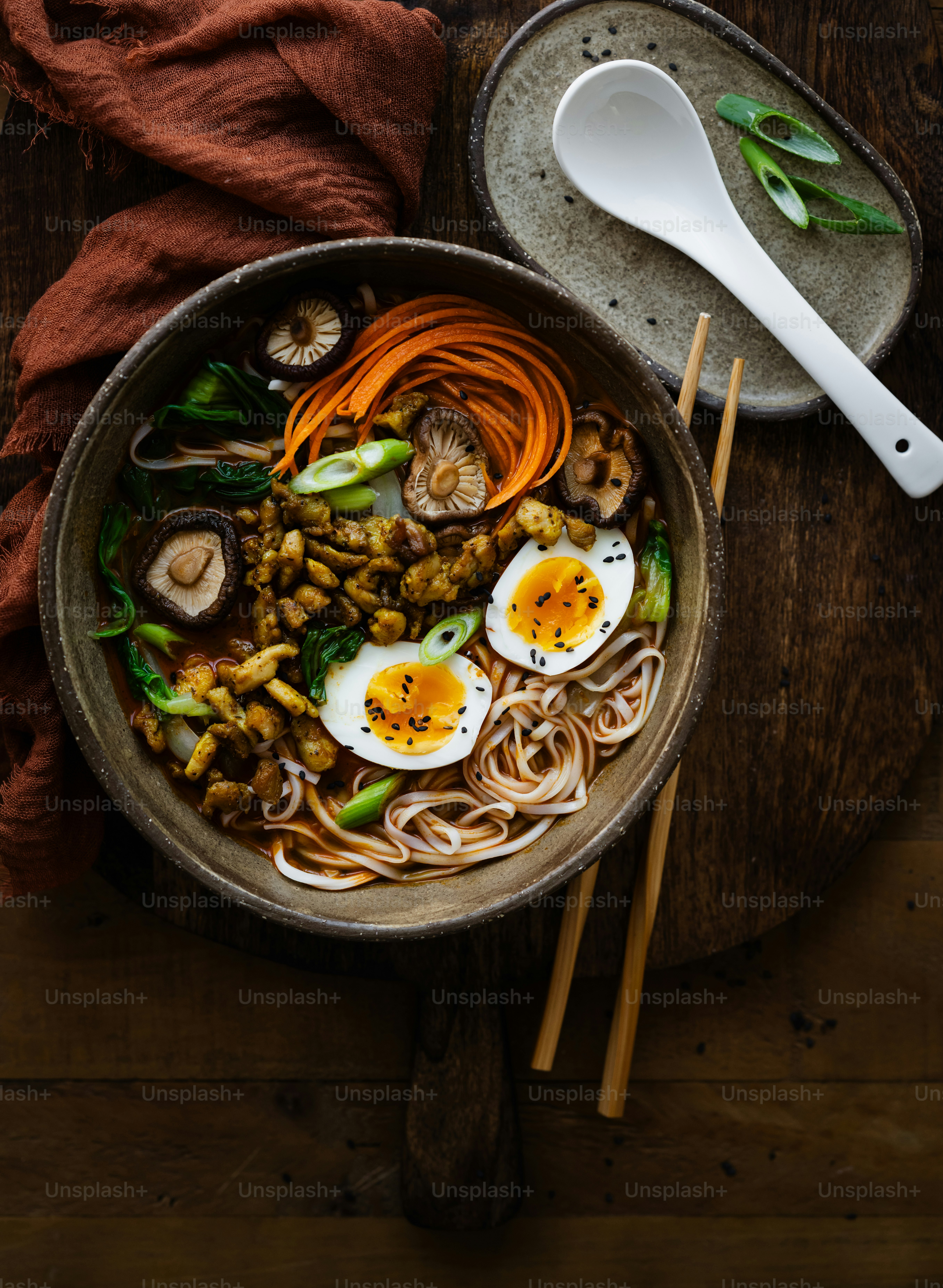a bowl of noodles, carrots, mushrooms, and hard boiled eggs