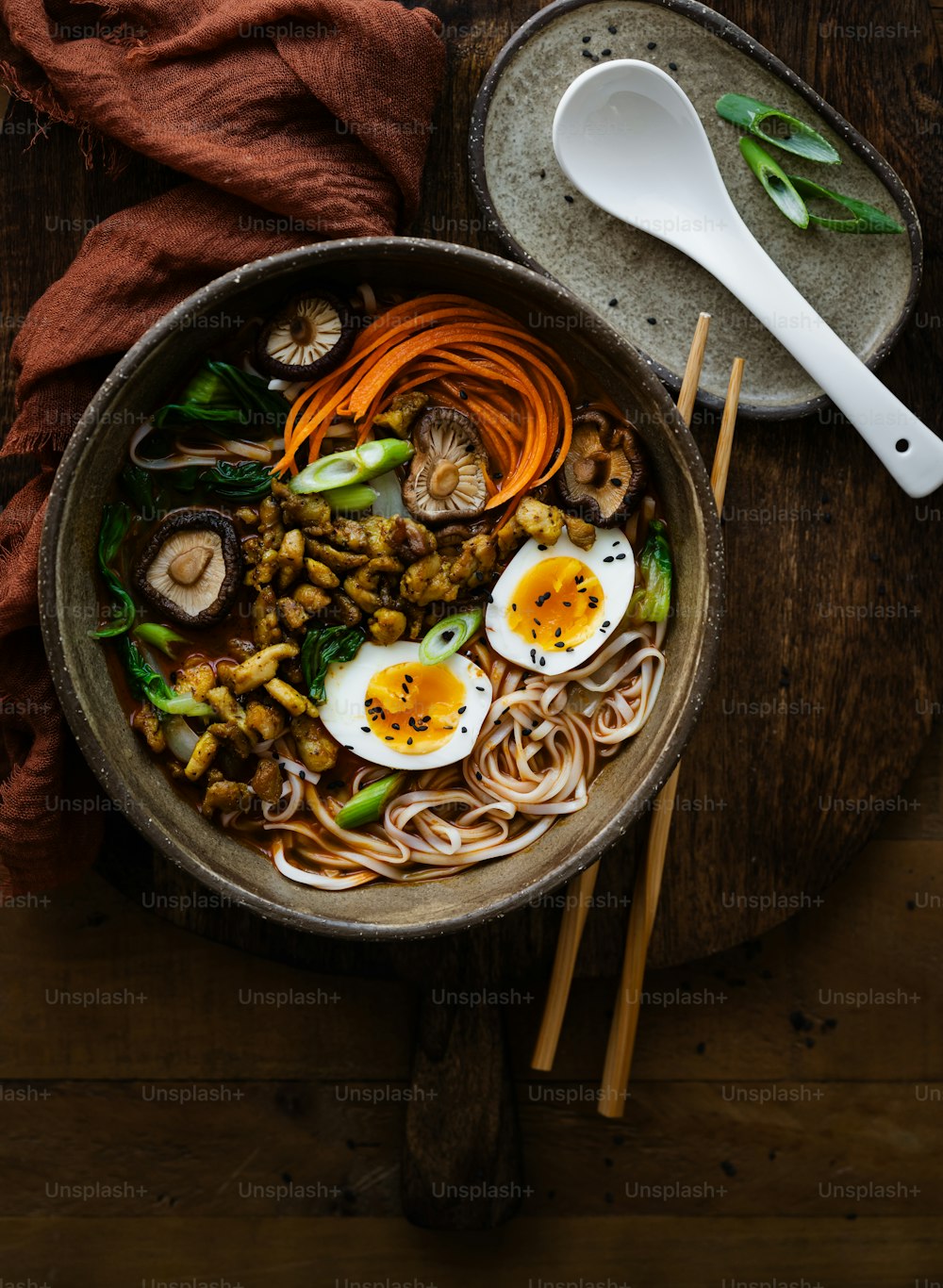 a bowl of noodles, carrots, mushrooms, and hard boiled eggs