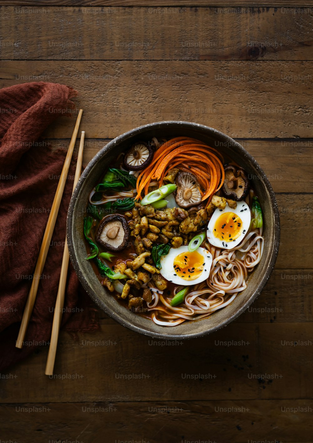 a bowl of noodles, carrots, mushrooms, and eggs