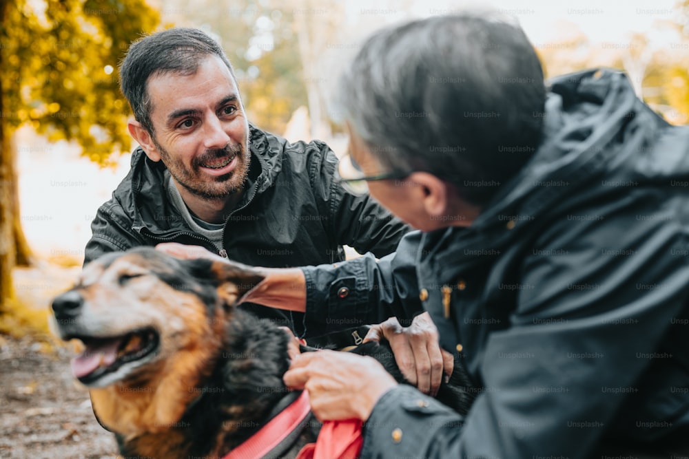 a man petting a dog while another man looks on