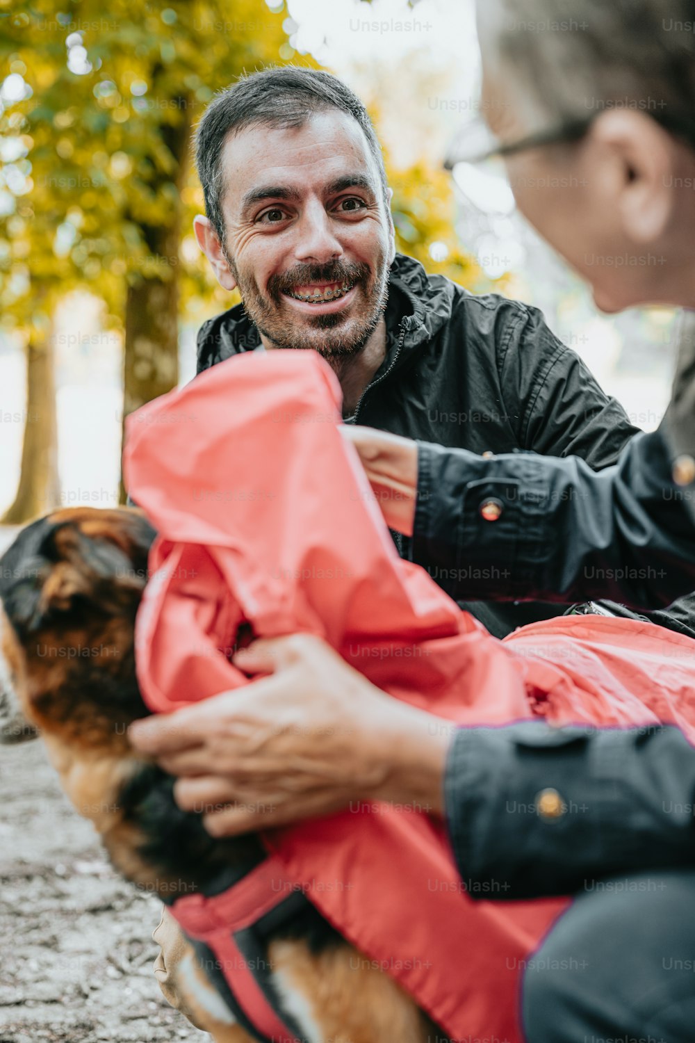 a man sitting on the ground petting a dog