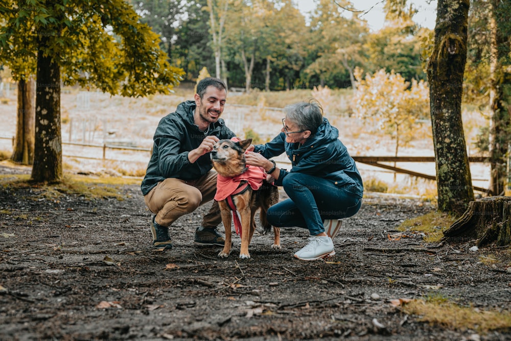 a man and a woman petting a small dog